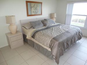 una camera da letto con un letto, una lampada e una finestra di Spanish Main Unit 4- Direct Oceanfront Condo! a Cocoa Beach Altre 37 foto