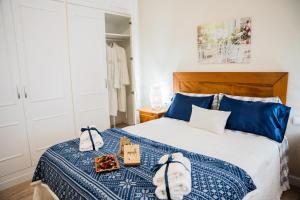 a bedroom with a bed with a blue and white blanket at Gallimó Apartaments in L'Ampolla