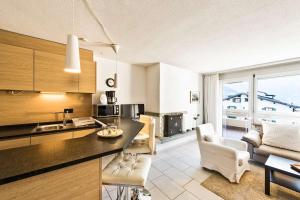 een keuken en een woonkamer met een tafel en stoelen bij Quadern Apartmenthaus B204 in Bad Ragaz