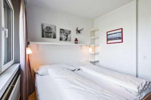 um quarto com uma cama branca e uma janela em Quadern Apartmenthaus B204 em Bad Ragaz