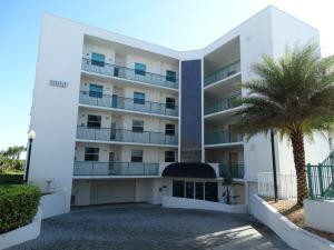 an apartment building with a palm tree in front of it at 3800 Ocean Blvd Luxury 501- Direct Oceanfront Condo! in Cocoa Beach