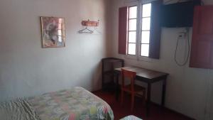 a bedroom with a bed and a desk and a window at Gran Hotel in Arequipa