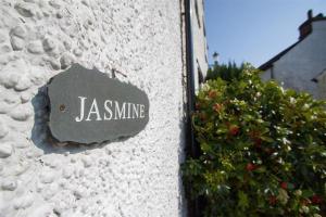 een stenen bord aan de zijkant van een gebouw bij Jasmine Cottage in Windermere