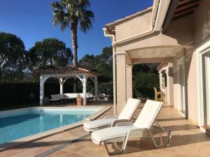 um grupo de cadeiras brancas ao lado de uma piscina em Magnifique villa avec piscine en Provence Verte em La Roquebrussanne