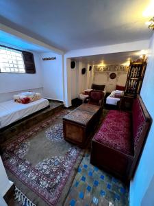 フェズにあるRiad dar Kiramiのベッド2台、椅子、ソファが備わる客室です。