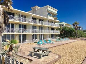 a building with a picnic table in front of it at Renovated, Ocean Beach Villas Unit 201- Direct Oceanfront Condo! in Cocoa Beach