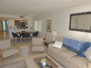 een woonkamer met een bank, stoelen en een tafel bij Renovated, Ocean Beach Villas Unit 201- Direct Oceanfront Condo! in Cocoa Beach