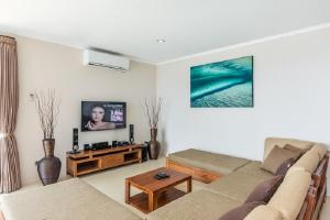 a living room with a couch and a tv at Villa Giuliana in Senggigi 