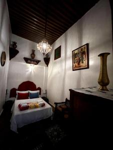 a bedroom with a bed and a table with a lamp at Riad dar Kirami in Fez