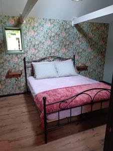 1 dormitorio con 1 cama con papel pintado con motivos florales en Vakantiewoning De Koolboet, en Koedijk