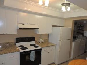 uma cozinha com armários brancos, um fogão e um frigorífico em Ocean Beach Villas Unit 302- Direct Oceanfront Condo! em Cocoa Beach
