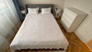a bedroom with a bed with a white comforter at Apartament Mony in Timişoara