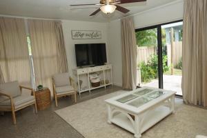 a living room with a television and a table and chairs at NEW! 219 Garfield Ave in Cocoa Beach