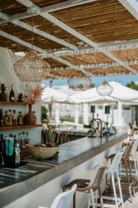 un bar al aire libre con sillas blancas y luces en Trabukos Beach Complex, en Kavos