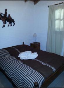 a bedroom with a bed with a horse on the wall at Cabañas Tia Elmira in Villa Cura Brochero