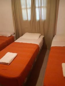 2 camas sentadas junto a una ventana en una habitación en Cabañas Tia Elmira en Villa Cura Brochero