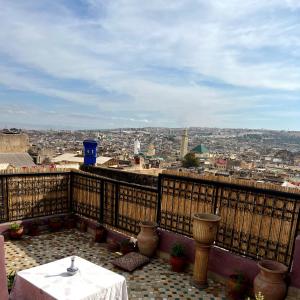 a balcony with a table and a view of a city at Riad dar Kirami in Fès