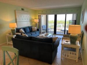 a living room with a couch and a table and chairs at Sandcastles 704- Space Coast Oceanview! in Cocoa Beach