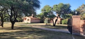 a park with a fence and trees and a bench at Cabañas Tia Elmira in Villa Cura Brochero