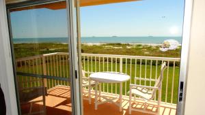 d'un balcon avec une chaise et une vue sur l'océan. dans l'établissement Spanish Main 63- Rare Direct Oceanfront 3 BR Condo!, à Cocoa Beach