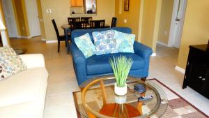 a living room with a blue couch and a glass table at Windsor Hills Resort- 401 in Orlando