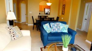 a living room with a blue couch and a dining room at Windsor Hills Resort- 401 in Orlando