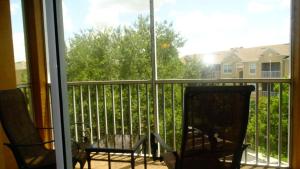 a screened in porch with two chairs and a window at Windsor Hills Resort- 401 in Orlando