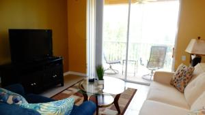 a living room with a white couch and a tv at Windsor Hills Resort- 401 in Orlando