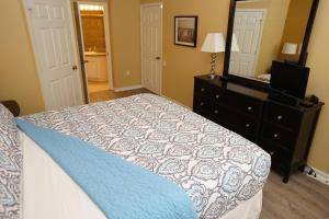 a bedroom with a bed and a dresser and a mirror at Windsor Hills Resort- 401 in Orlando