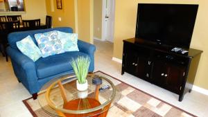 a living room with a blue couch and a tv at Windsor Hills Resort- 401 in Orlando