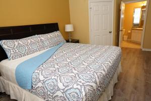a bedroom with a bed with a blue and white blanket at Windsor Hills Resort- 401 in Orlando