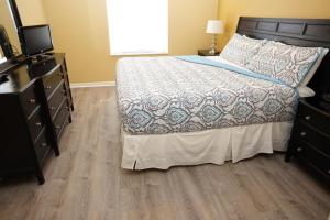 a bedroom with a bed and a dresser and a television at Windsor Hills Resort- 401 in Orlando