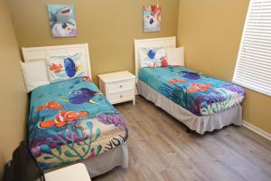 two beds in a room with two bedsskirtspectspectspectspectspects at Windsor Hills Resort- 401 in Orlando +37 photos