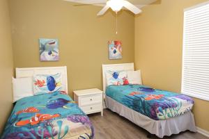 two beds in a childs bedroom with fish decorations at Windsor Hills Resort- 401 in Orlando