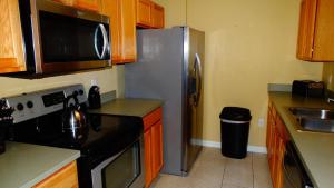 a kitchen with a stainless steel refrigerator and a microwave at Windsor Hills Resort- 401 in Orlando