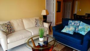 a living room with a white couch and a blue chair at Windsor Hills Resort- 401 in Orlando