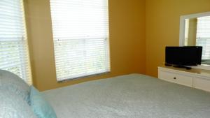 a bedroom with a bed and a flat screen tv at Windsor Hills Resort- 401 in Orlando