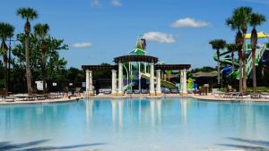 a large swimming pool in a park with a roller coaster at Windsor Hills Resort- 401 in Orlando