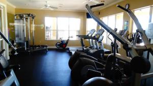 a gym with several tread machines in a room at Windsor Hills Resort- 401 in Orlando