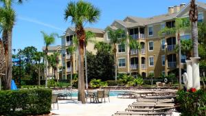 a resort with a pool and chairs and palm trees at Windsor Hills Resort- 401 in Orlando