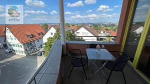 balcón con mesa y sillas en KRYSTALL Hotel, en Filderstadt