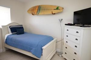 a bedroom with a bed and a surfboard on the wall at WOW! Updated Oceanfront, Pool Front Spanish Main Condo 45! in Cocoa Beach