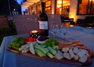 a plate of cheese and vegetables on a table with a bottle of wine at Lilea's Castle in Lílaia