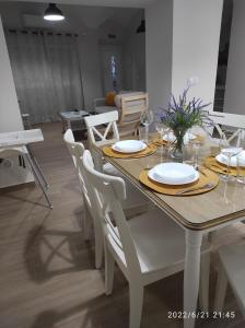 a dining table and chairs with plates and glasses on it at Bonita y amplia casa con patio, en centro ciudad in Mérida