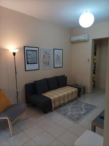 een woonkamer met een bank en een lamp bij Happy holiday apartment in Artemida