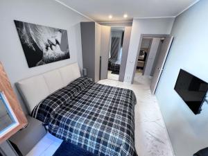 a bedroom with a bed and a tv on a wall at Le Porte luxury apartment in Aosta