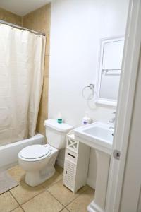 een badkamer met een toilet, een wastafel en een spiegel bij Entire Atlanta Condo Minutes from Downtown in Atlanta