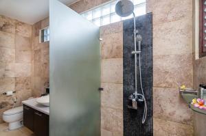 a bathroom with a shower with a glass door at Villa Keluarga in Nusa Lembongan +24 photos