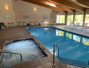 a large swimming pool in a hotel with tables and chairs at AppleCreek Resort-Hotel & Suites in Fish Creek