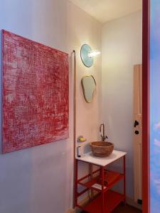 La salle de bains est pourvue d'un lavabo et d'une grande peinture murale. dans l'établissement Bed & Binnekyk, à Malines